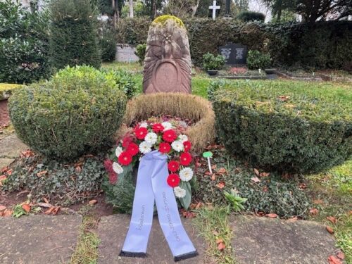 Das Grab von Carlo Schmid mit einem Kranz mit roten und weißen Blumen, auf der Schlaufe steht: "In Gedenken" und "Carlo-Schmid-Stiftung"